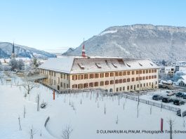 Imposing monastery building in a snowy landscape, low mountains behind